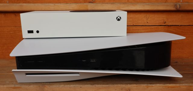 La Xbox Series S posando encima de una PlayStation 5.