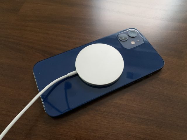 Apple MagSafe charger attached to an iPhone 12.