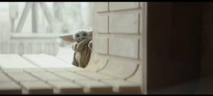 Baby Yoda looks at the Mandalorian through an open door