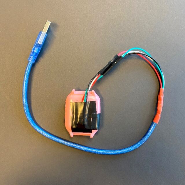 A modified USB cable attached to the back of an X4 watch.