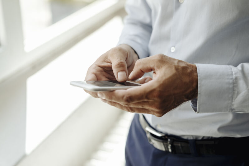 Stock photo of man using smartphone.