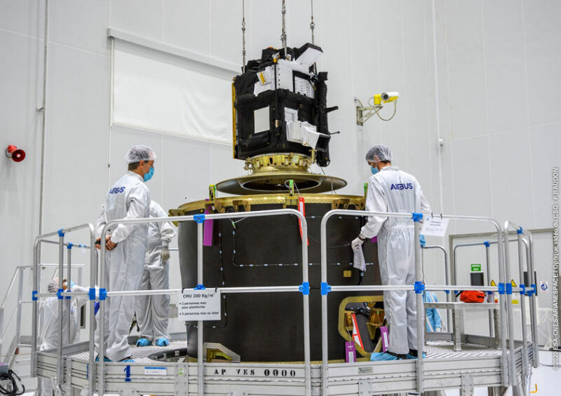 images of people in clean suits standing near metal hardware.