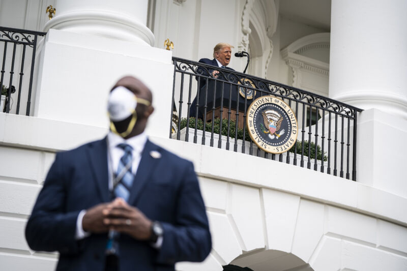 A member of the uniter states secret service wearing a face mask stands guard as President Donald J. Trump speaks to supporters from the Blue Room balcony during an event at the White House on Saturday, Oct 10, 2020 in Washington, DC. 