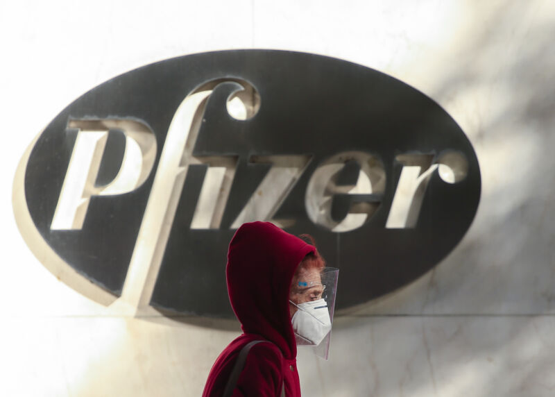 A woman wears a facemask as she walks by the Pfizer world headquarters in New York on November 9, 2020.