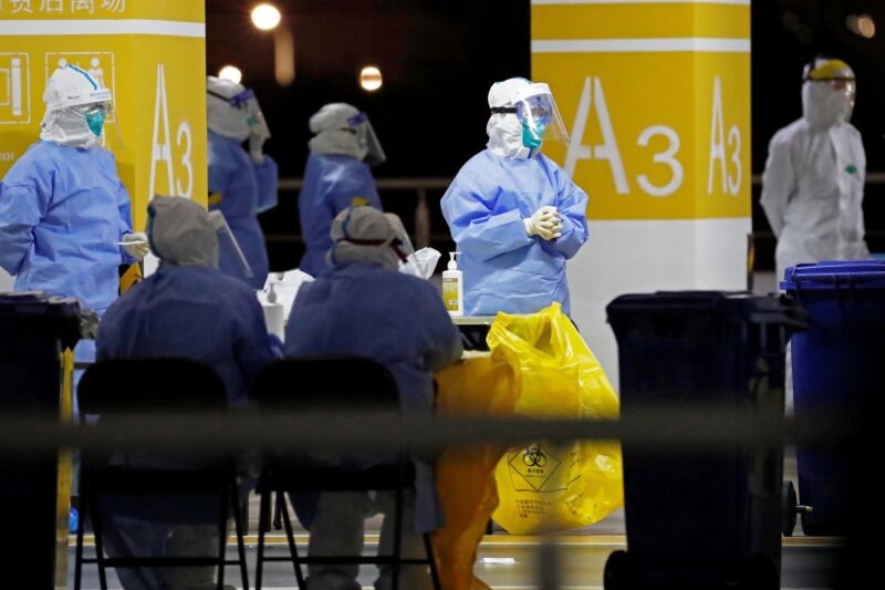 This photo taken on November 22, 2020 shows health workers in protective suits waiting to conduct COVID-19 coronavirus tests on staff at Pudong Airport in Shanghai. 