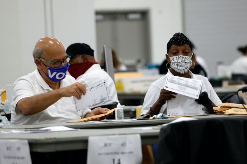 Election workers in Detroit sitting at a table and counting ballots.