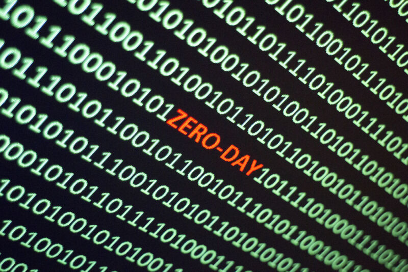 The word ZERO-DAY is hidden in the middle of a screen full of ones and zeros.
