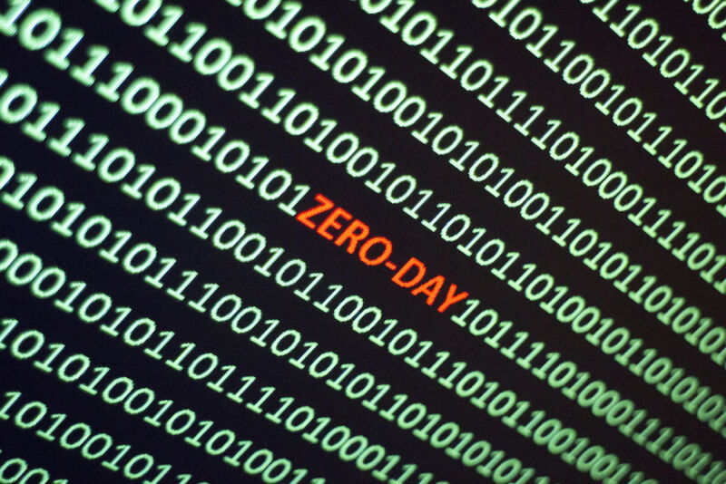 The word ZERO -DAY is hidden in the middle of a screen full of ones and zeros.