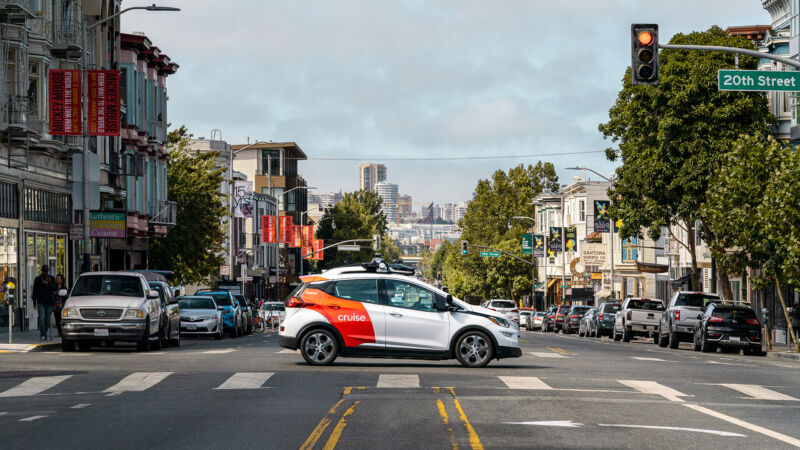 A hatchback with Cruise branding drives through San Francisco.