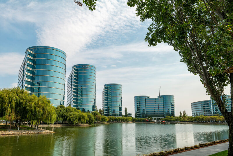 Multi-storey glass buildings ring a retention dam.