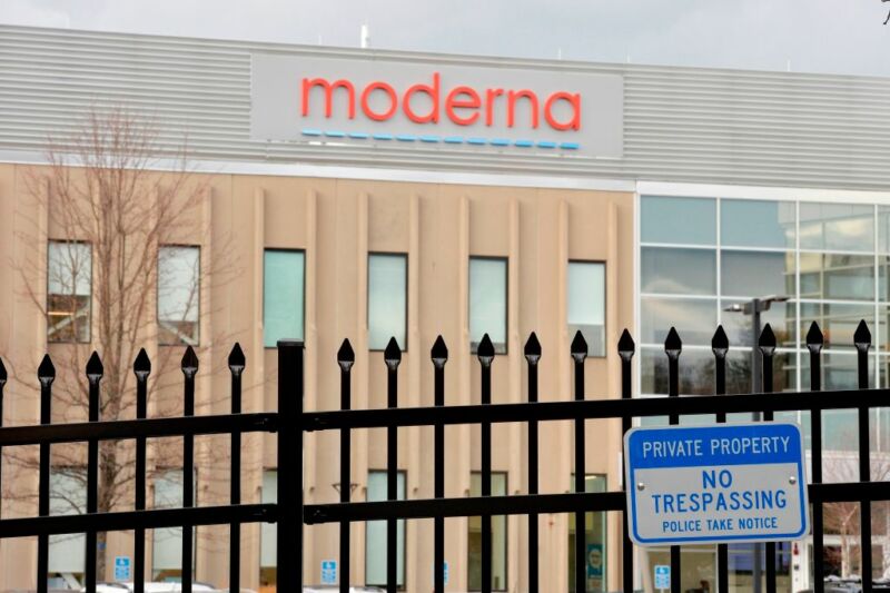 Image of a building with the Moderna logo behind a security fence.