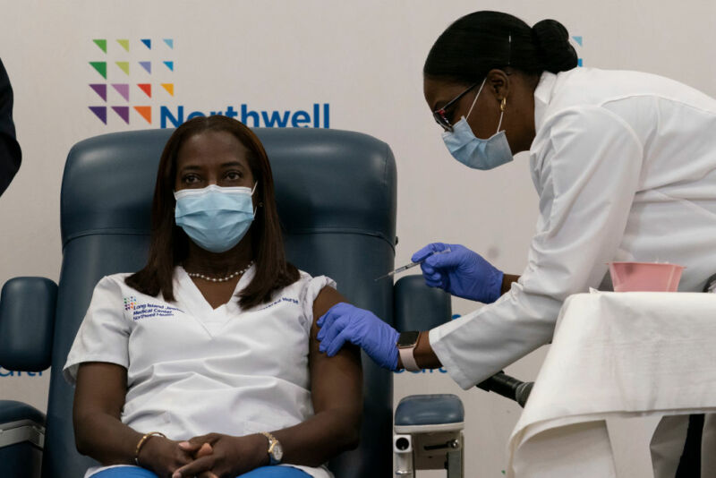 Image of a seated woman receiving an injection.