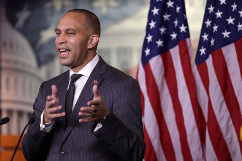 A man in a suit speaks from a podium.