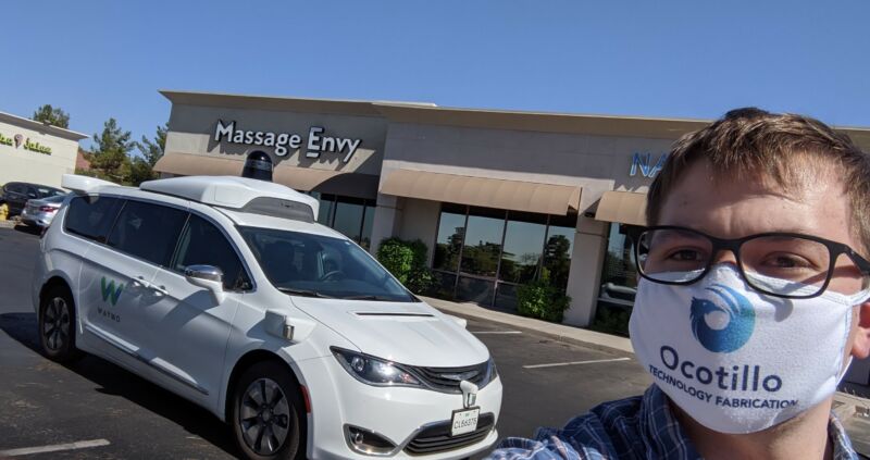 Joel Johnson with a driverless Waymo vehicle.