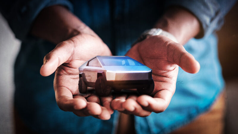 A stock photo has been photoshopped to show a man holding an entire truck in his two hands.