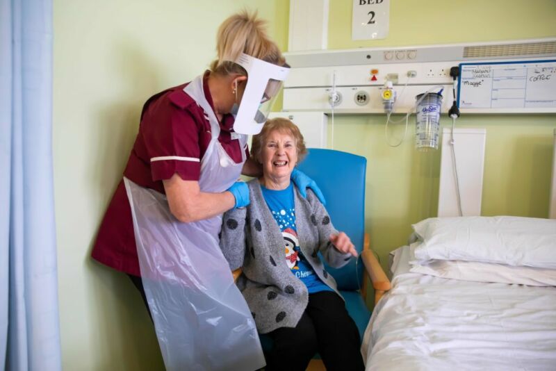 Margaret Keenan, 90, who was the first in the UK to receive the first installment of two doses of Pfizer-BioNTech COVID-19 vaccine, responds as she talks to Lorraine Hill, a health assistant, as she prepares to leave Coventry University Hospital.  Coventry on December 9, 2020, one day after vaccination.