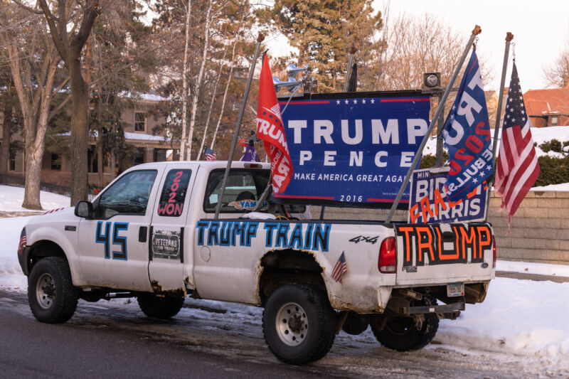 A white pickup truck is decorated in pro-Trump paraphernalia.