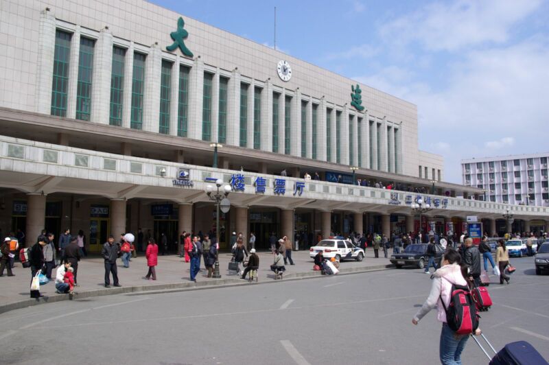 Passengers pulling a baggage ring from a concrete terminal squat