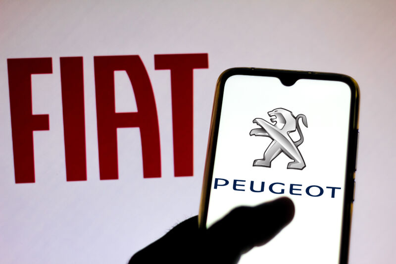 BRAZIL - 2019/12/18: In this photo illustration the Peugeot logo is viewed on a smartphone and Fiat Automobiles logo on a blurred background.
