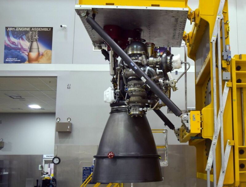 Rocket engine under construction inside a mammoth, white-walled hangar.