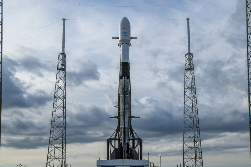 A space rocket is pointed towards the cloudy sky.