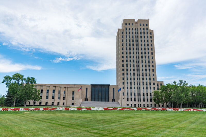 A wide lawn surrounds a 21-story Art Deco tower.