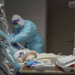 A medical staff member adjusts a ventilator on a patient in the COVID-19 intensive care unit (ICU) at the United Memorial Medical Center on December 2, 2020 in Houston, Texas. 
