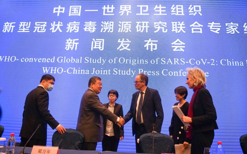 Liang Wannian (2nd L) and Peter Ben Embarek (3rd R), both members of the WHO-China joint research team, shake hands after the press conference of the WHO-China joint study in Wuhan, Hubei province in Central China, on February 9, 2021 . 