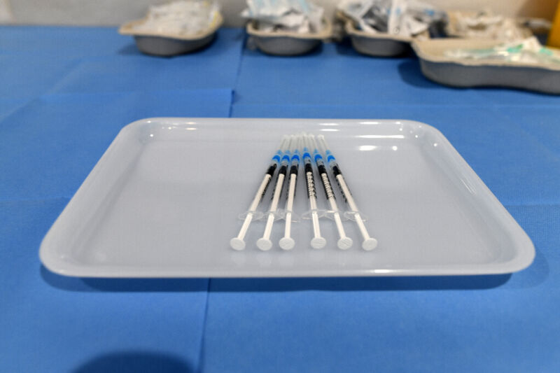 Hypodermic needles lined up in a tray.