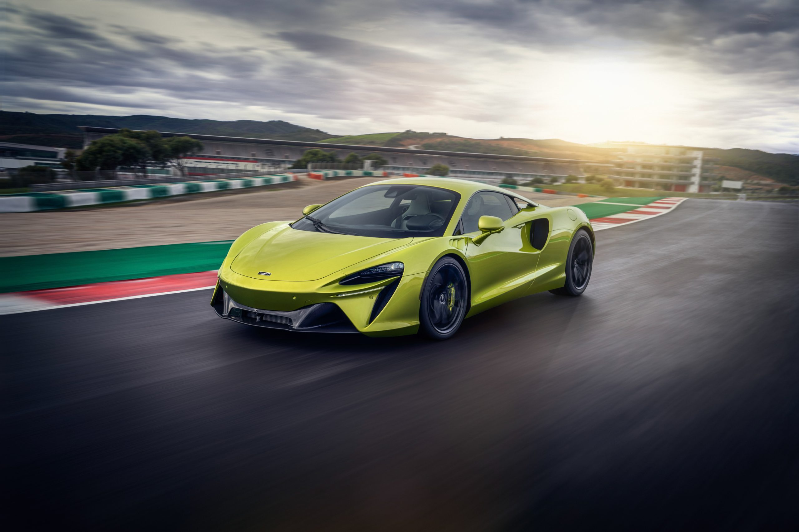 A green McLaren Artura on track