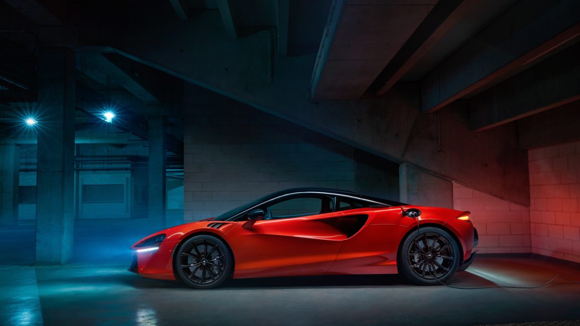 A red McLaren Artura plugged in to charge