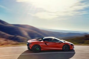 A red McLaren Artura on a mountain road