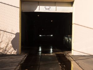 A VW ID.4's headlights can be seen in the darkness as it goes through a car wash