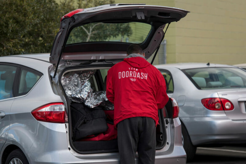 A DoorDash Inc. delivery person arranges an order in the back of a vehicle outside of a DoorDash Kitchens location in Redwood City, California.