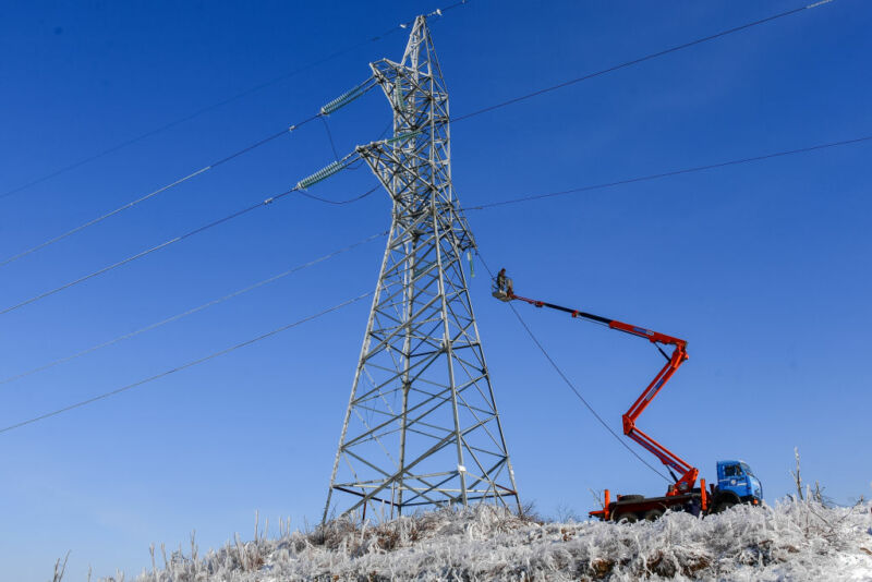 Una torre de línea eléctrica en un campo de hierba.