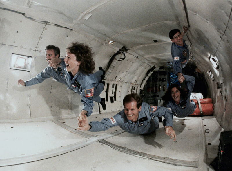 Puis le représentant Bill Nelson (D-Fla., En bas) en cours de formation à l'apesanteur à bord d'un KC-135 avec d'autres stagiaires astronautes en 1985. À sa droite se trouve l'instituteur Christa McAuliffe, décédé avec sept autres membres d'équipage dans le Désastre du <em> Challenger </em>. “/><figcaption class=