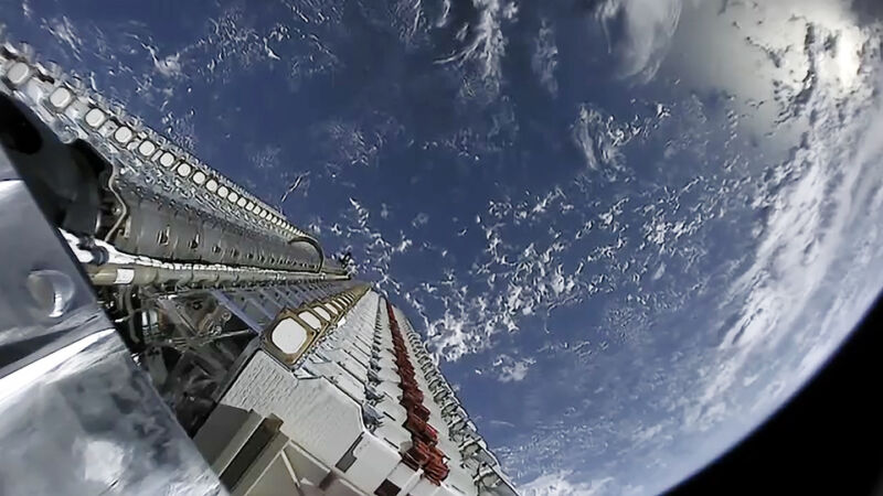 A stack of 60 Starlink satellites is launched into space, with Earth in the background.