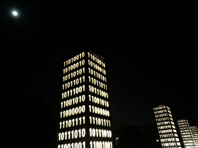 Image of a pillar covered in lit ones and zeroes.