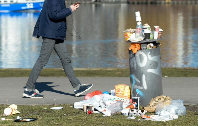 Image of food waste at a trash can in a park.