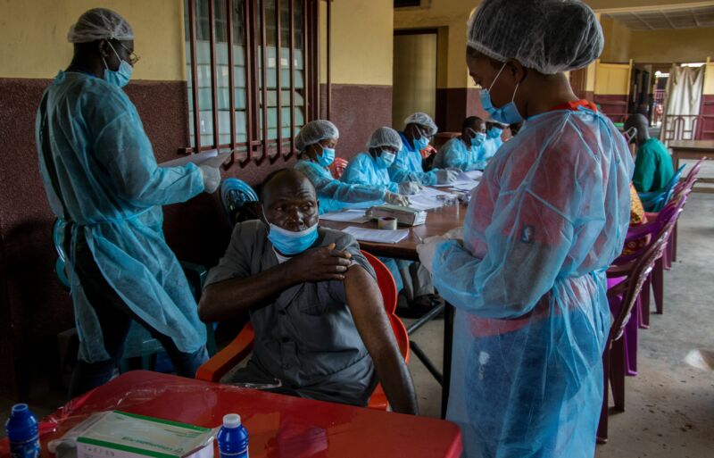 A N'zerekore Hospital staff member lifts his shirt sleeve as he prepares to receive his anti-Ebola vaccine on 24 February 2021 in N'zerekore.  Nzerekore Hospital was where the first cases of Ebola were found at the end of January 2021.  . 