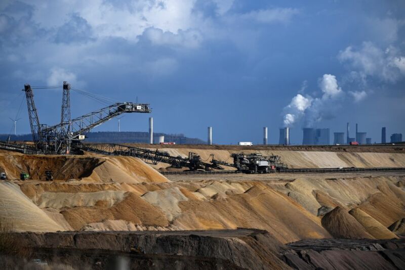 Image of a mine with a power plant in the background.