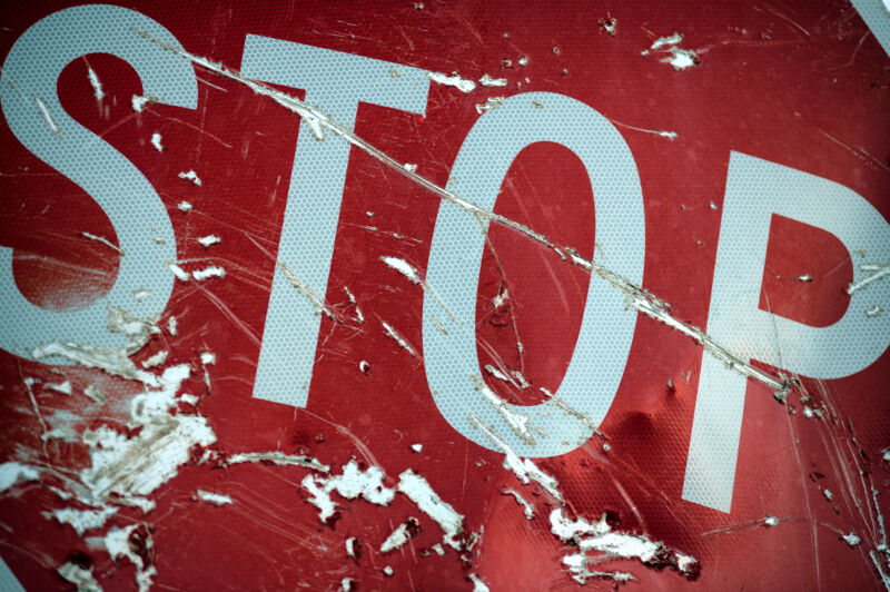 A metal STOP sign has been scratched extensively.