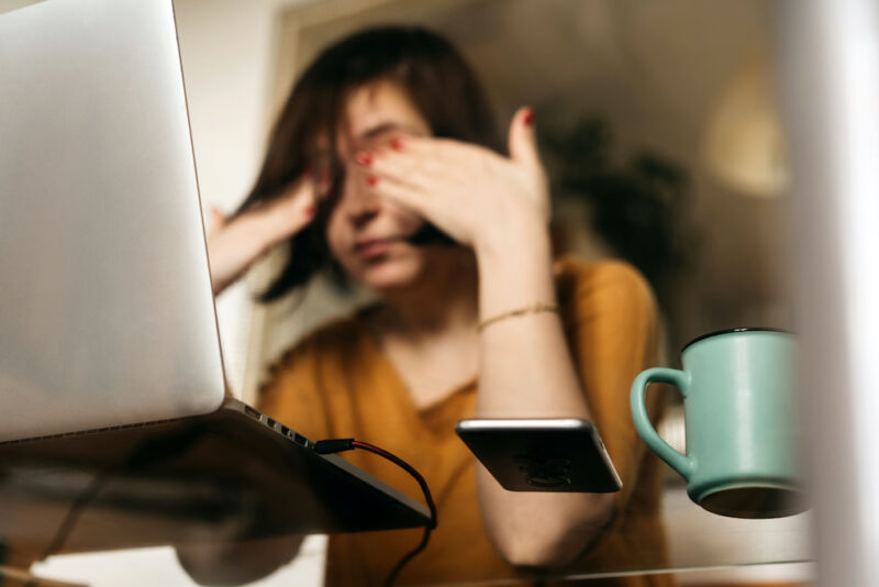 Una mujer de mediana edad sentada en la cocina en la mesa de cristal