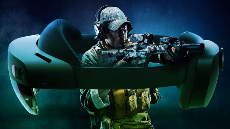 A soldier raises a rifle from within a comically oversized headset.