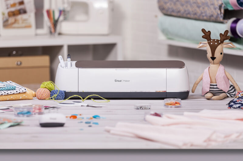 A Cricut maker in its natural habitat: a carefully staged table full of miscellaneous crafting bits.