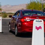 A car waits for passengers beside traffic cones labelled "Lyft."