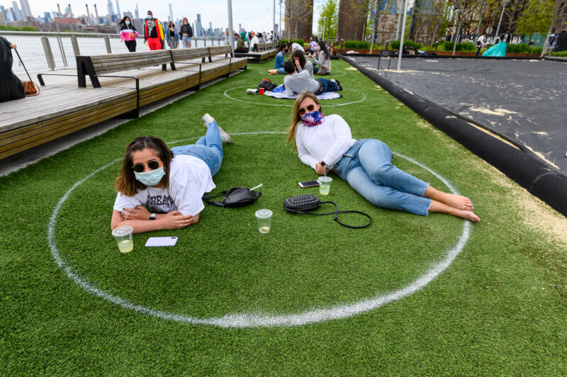 People practice social distancing in white circles in Domino Park in Williamsburg during the coronavirus pandemic on May 17, 2020, in New York City. 