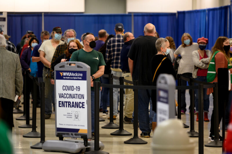 Residents wear protective masks while waiting to be vaccinated at a West Virginia United Health System Covid-19 vaccine clinic in Morgantown, West Virginia, U.S., on Thursday, March 11, 2021. 