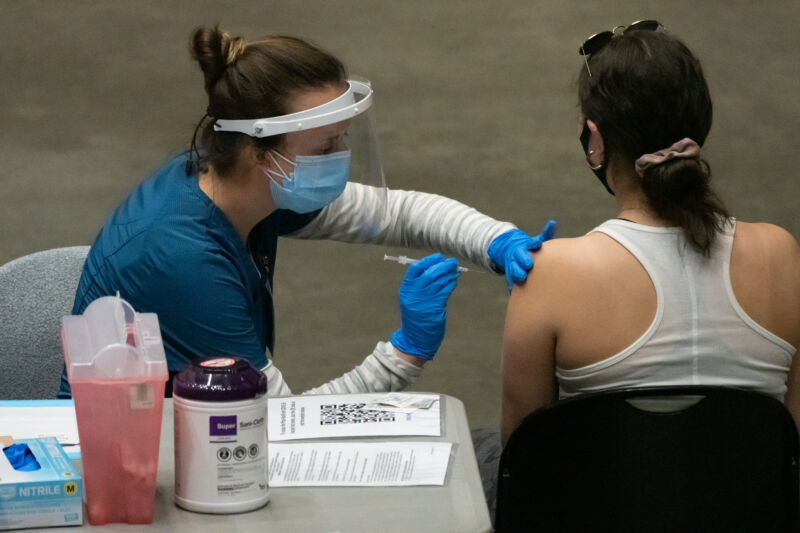 Un travailleur de la santé administre une dose du vaccin Pfizer-BioNTech Covid-19 à l'intérieur de la Viejas Arena sur le campus de l'Université d'État de San Diego à San Diego, Californie, États-Unis, le jeudi 1er avril 2021. 