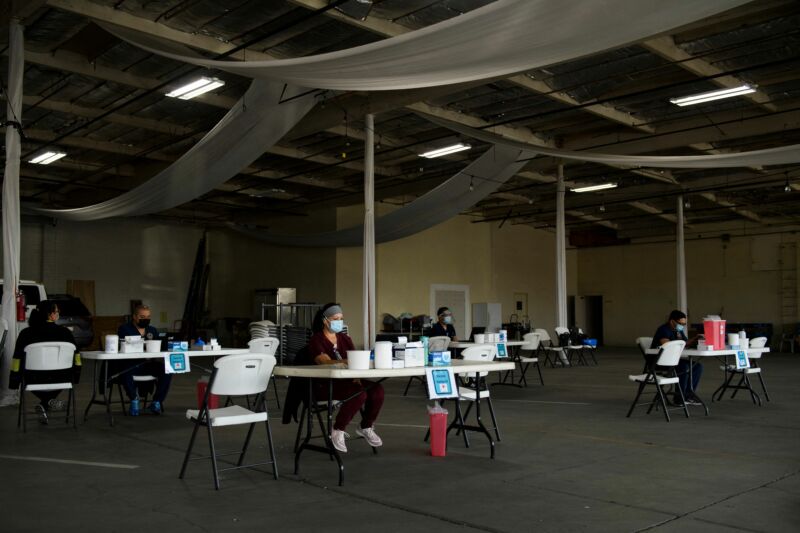 Nurses wait at empty tables for more patients to arrive to receive a dose of the Moderna Covid-19 vaccine at a pop-up vaccination site in Gardena, California on April 17, 2021.